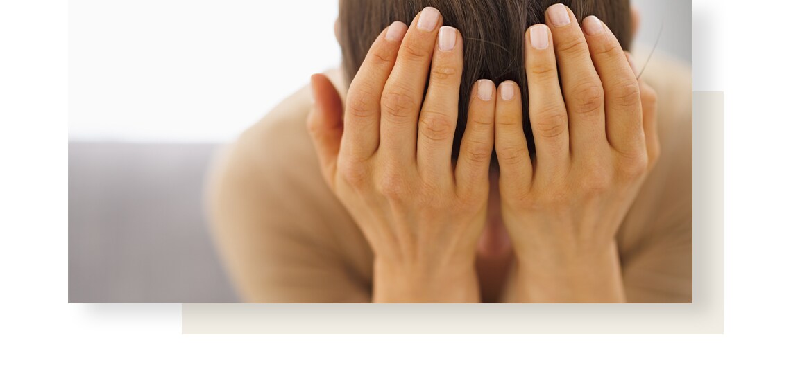 Woman suffering from nausea is holding her head with her hands