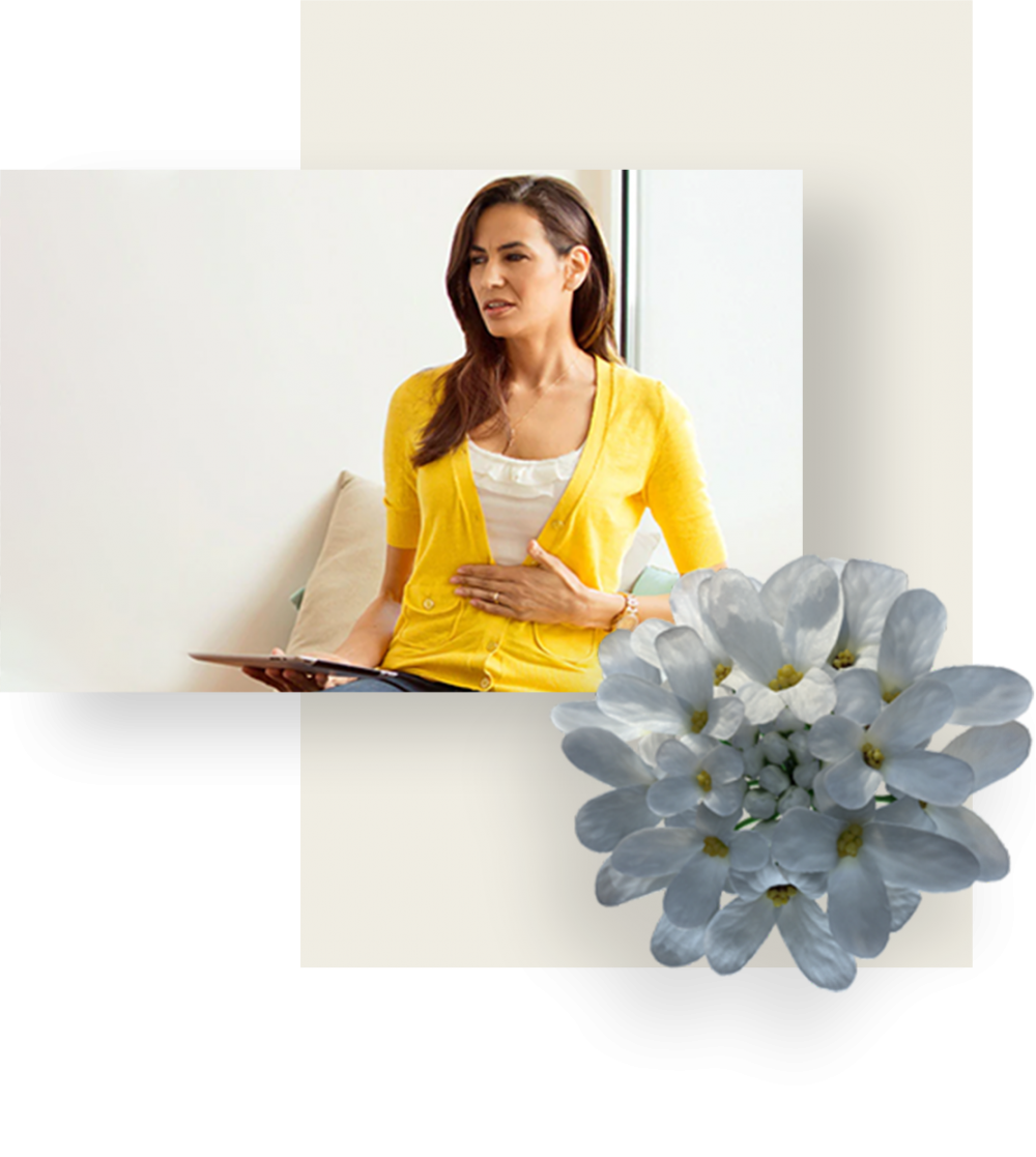 Woman wearing yellow sweater, suffering from stomach pain