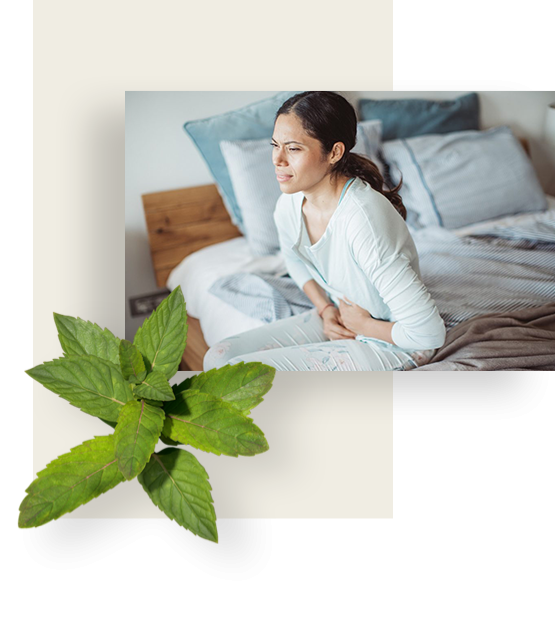A dark-hair woman on a side of her bed, suffering from stomach pressure.