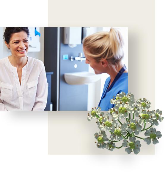 Female Physician, dressed in blue uniform is talking to her female patient.
