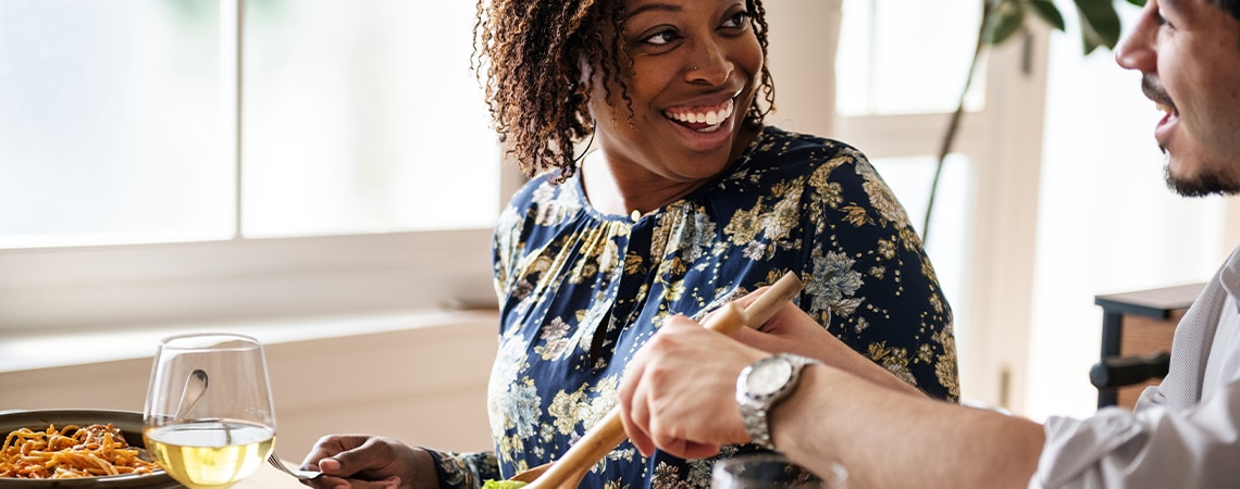 Women smiling while eating her meal.