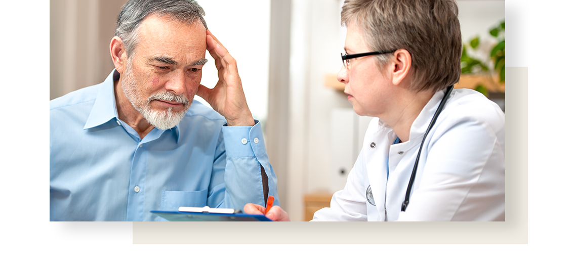 Female physician interviewing her middle aged male patient, who wears blue shirt.