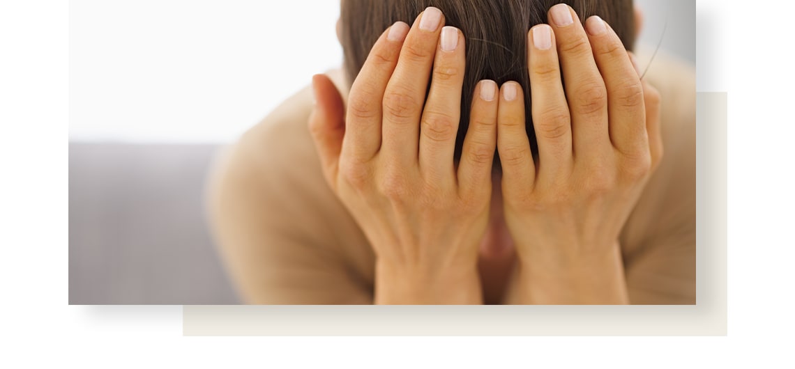 Woman suffering from nausea is holding her head with her hands