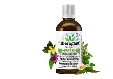 A bottle of Iberogast on green background, surrounded by herbs